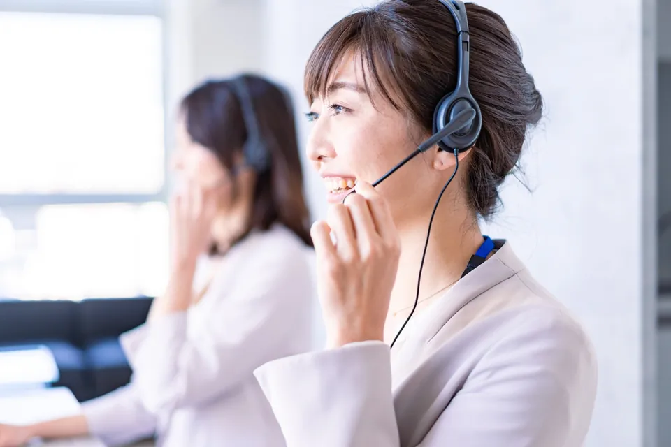 ヘッドセットで電話対応をする女性
